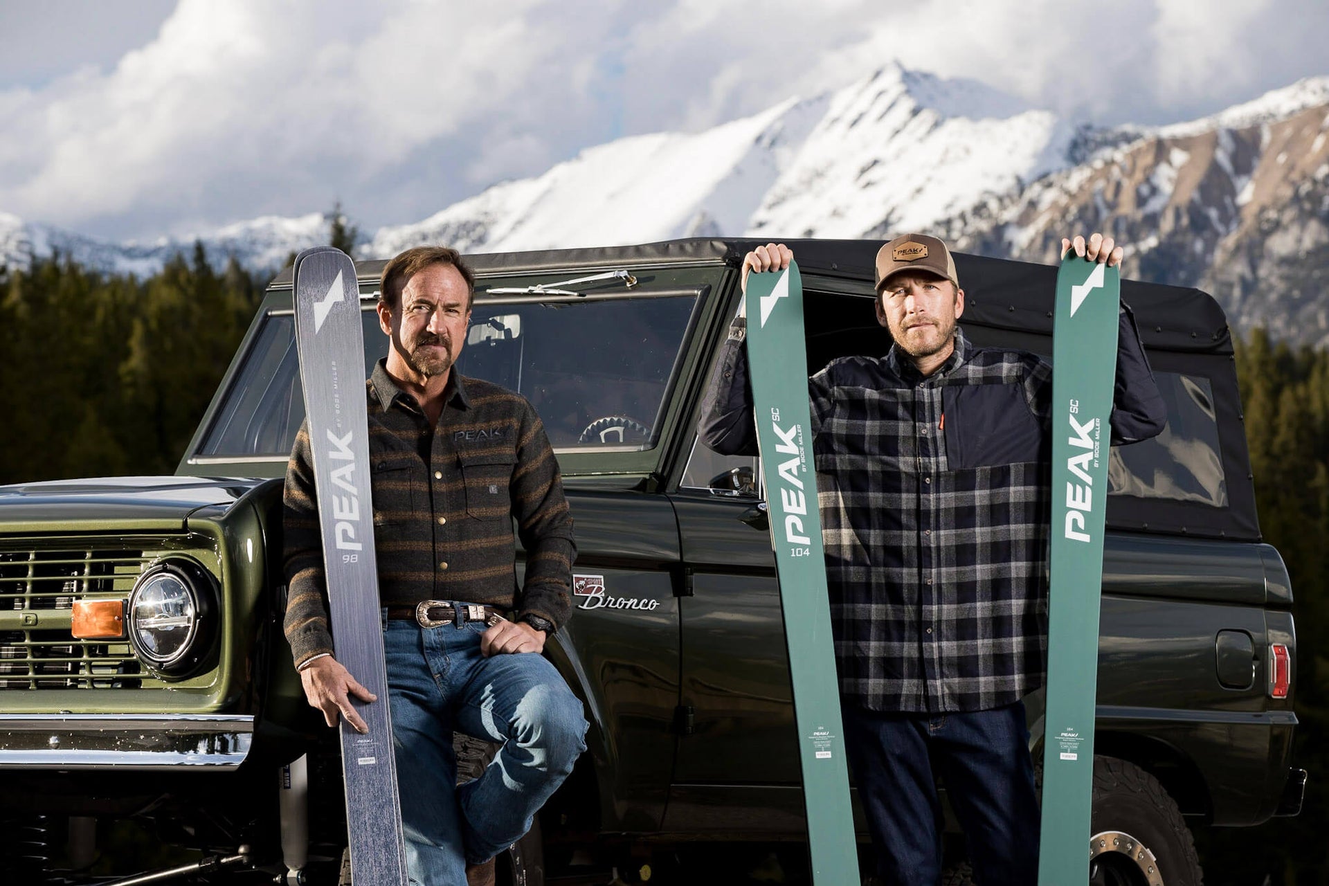 Bode Miller and Andy Wirth standing with skis in front of a truck