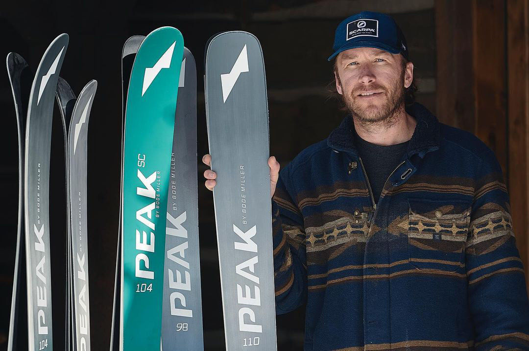 Bode Miller standing with Peak skis