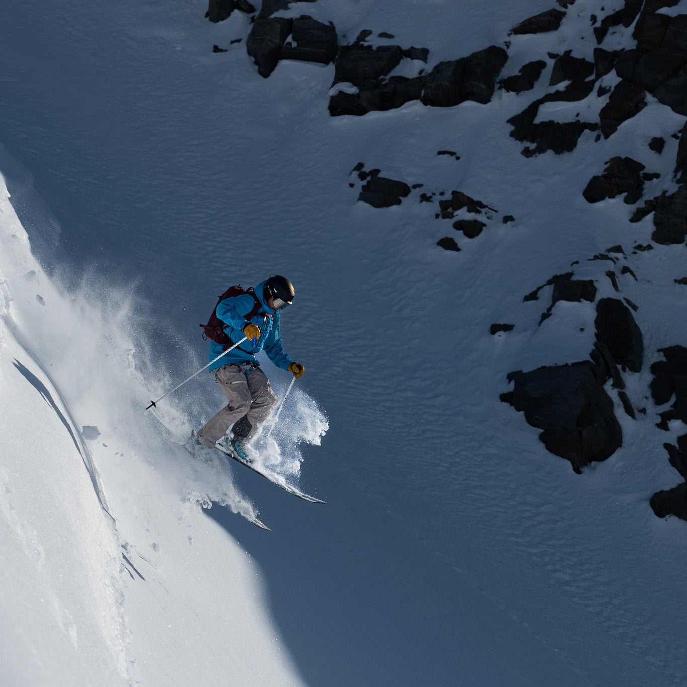 A skier dropping into pow