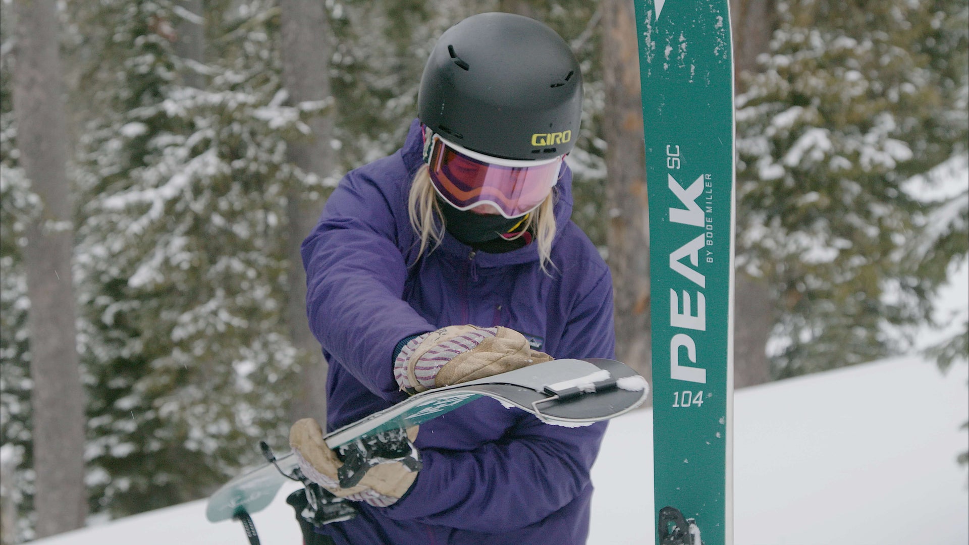 A women skier fixing skins onto skis